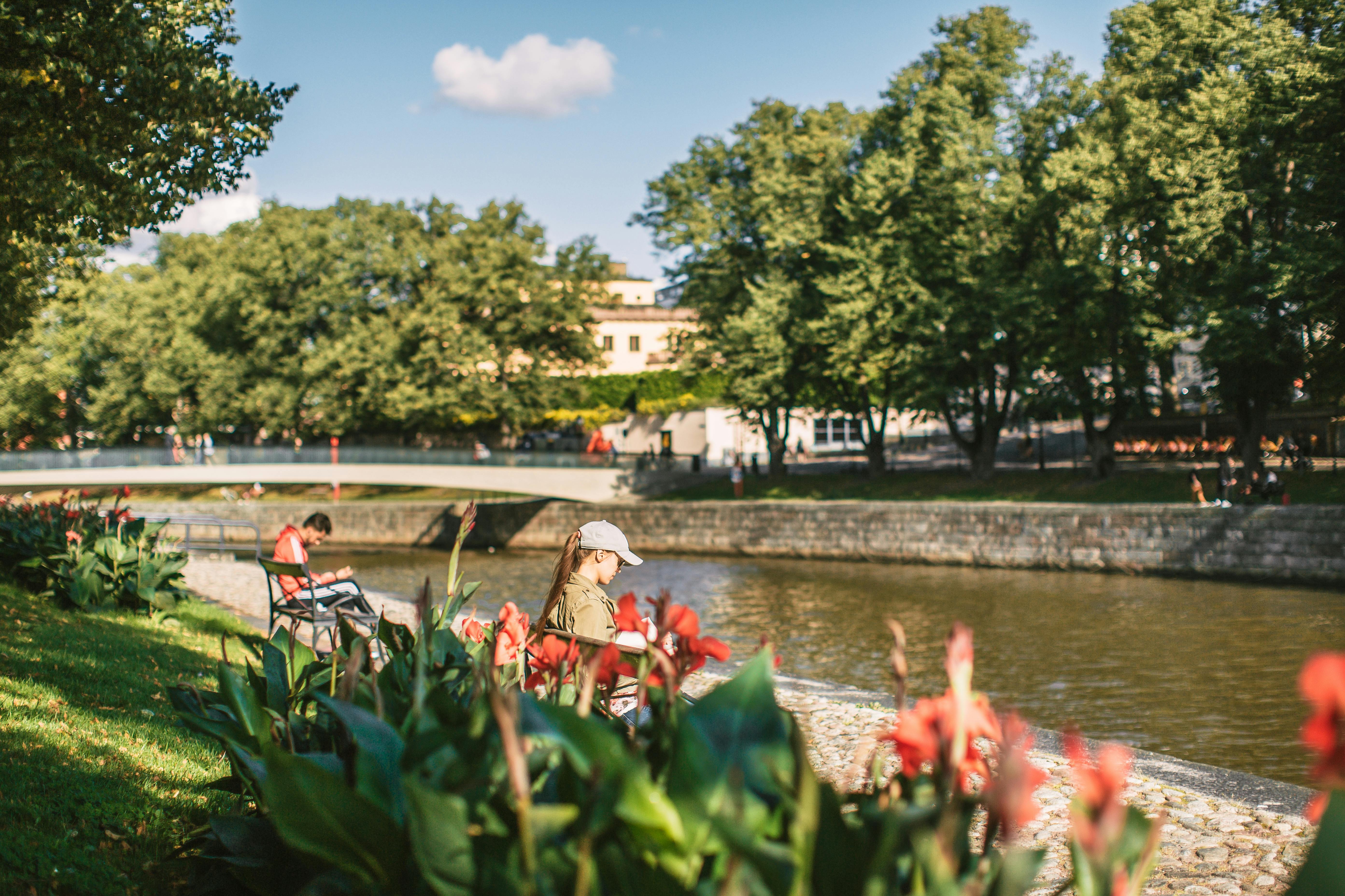 People enjoying the summer along the Aurajoki river.