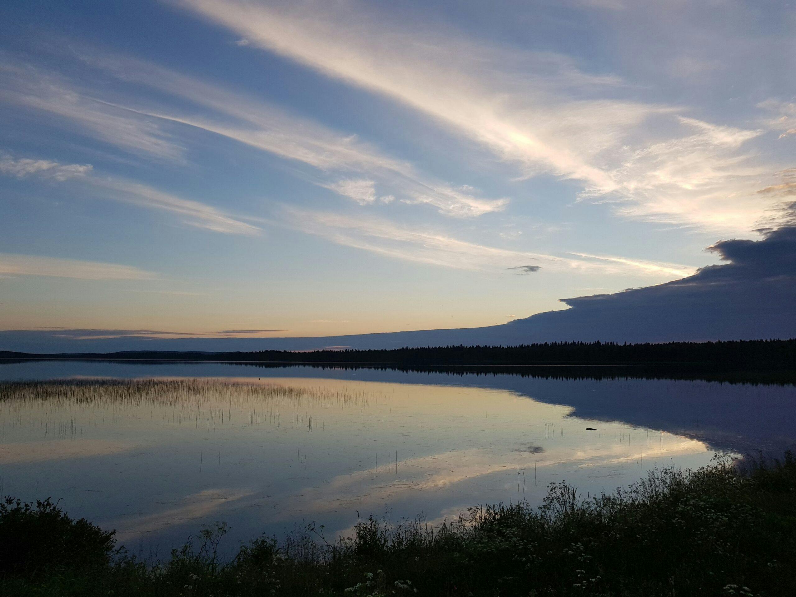 Yökävely pimeällä heijastaen upean maiseman järvelle.