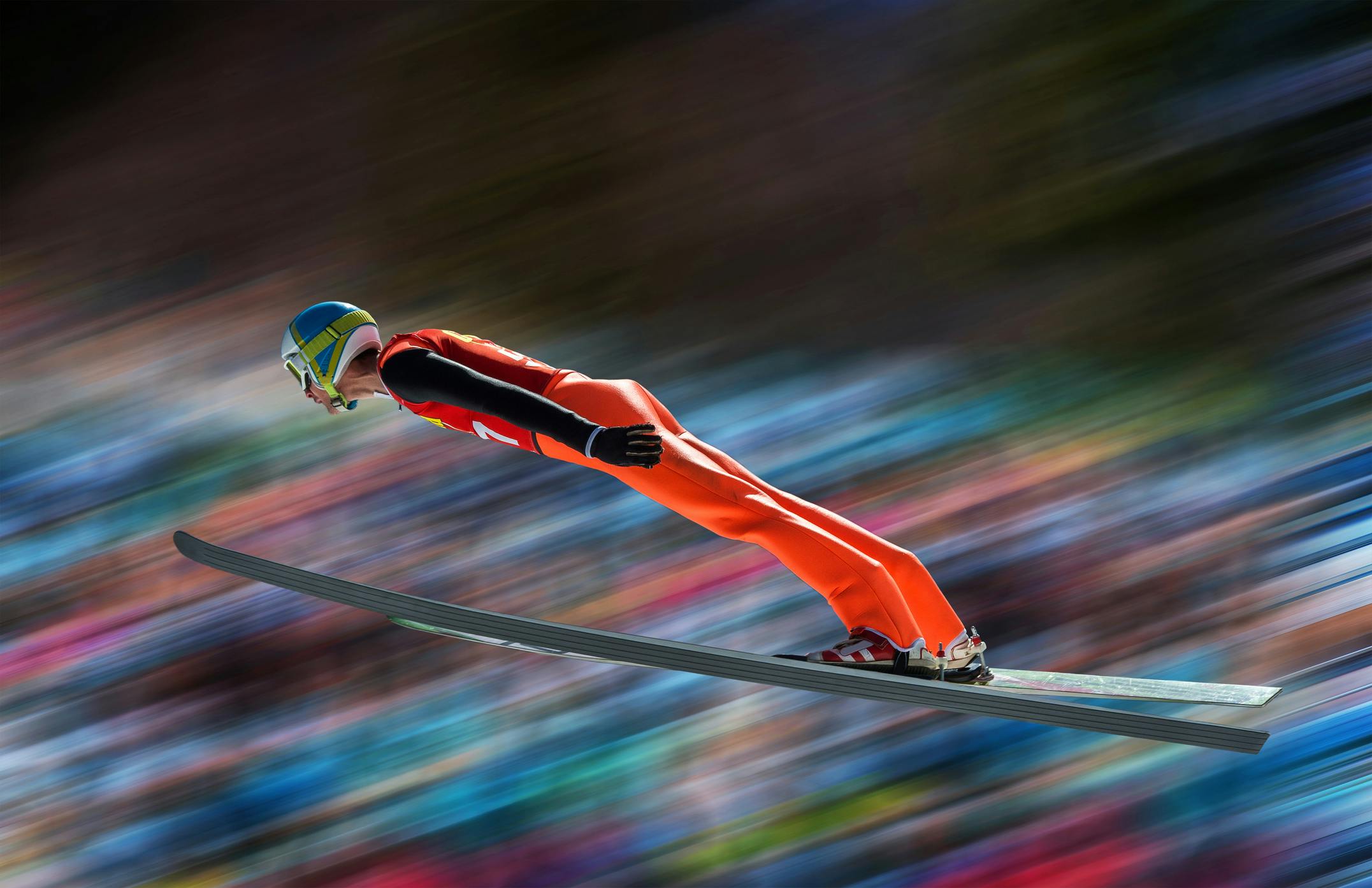 Ski jumper in mid-air against blurred background