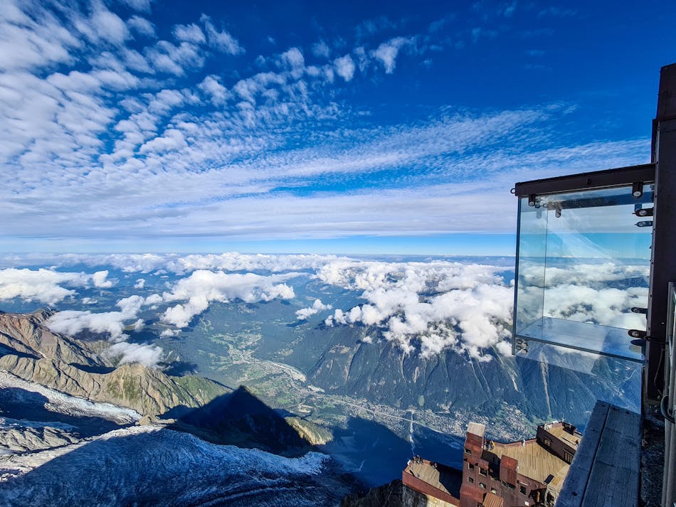 Chamonixissa sijaitseva Aiguille du Midi Vuoren ilmakuva. Vuoristo on pilven peitossa ja kuvaaja on näiden yläpuolella.