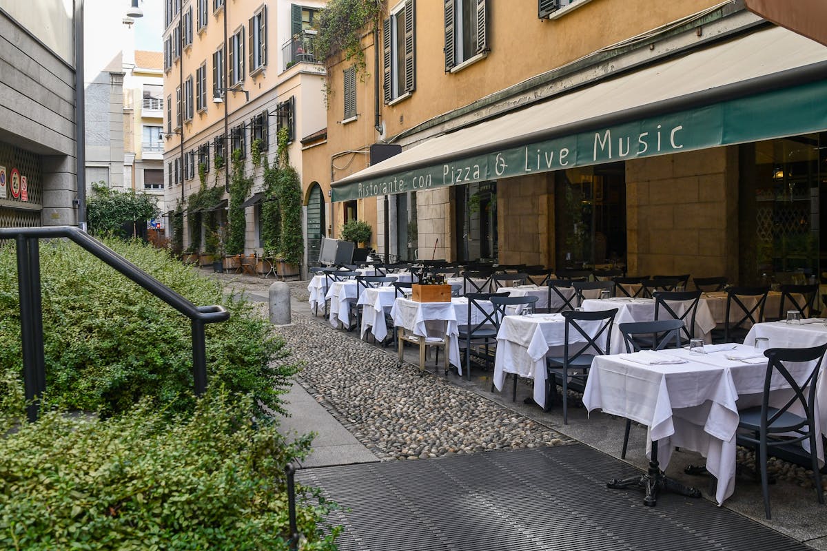 Ravintolan ulkopuoli pöydillä jalkakäytävällä Breran kaupunginosan kujalla, Milano, Lombardia, Italia