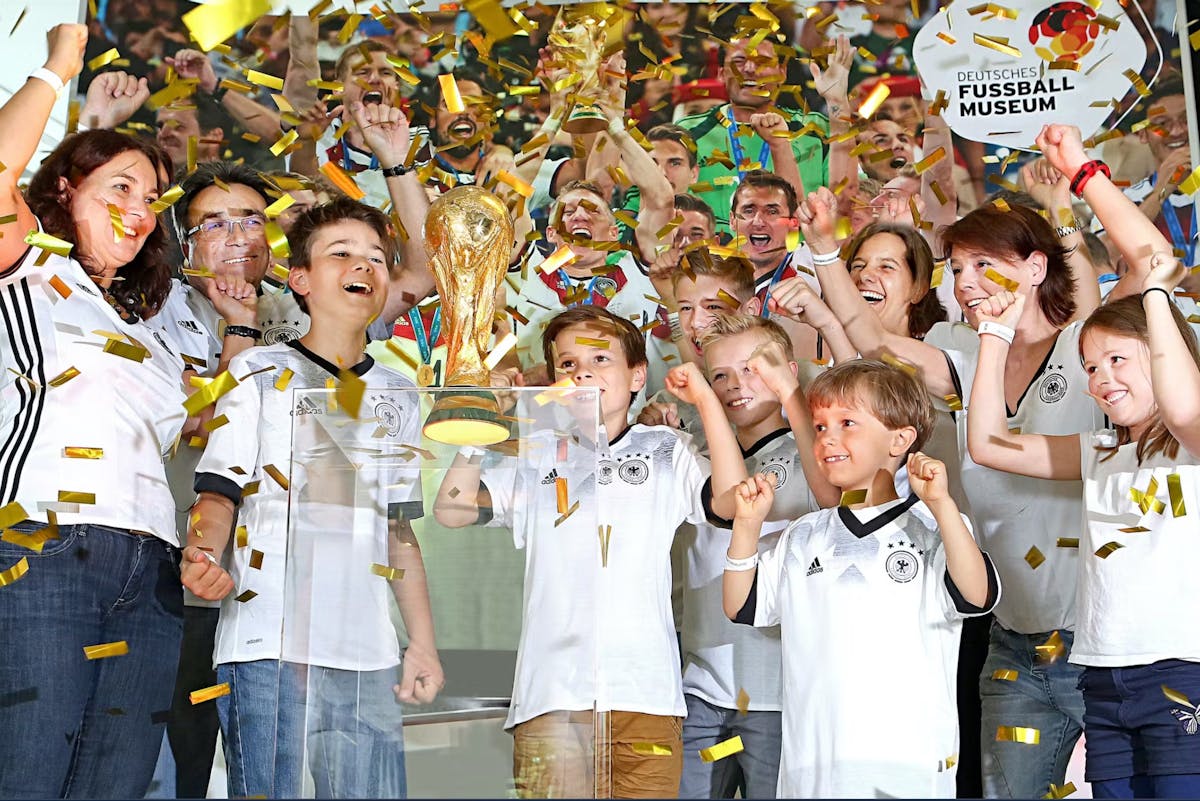 Dortmund jalkapallomuseossa iloisia lapsia palkinnon kanssa.