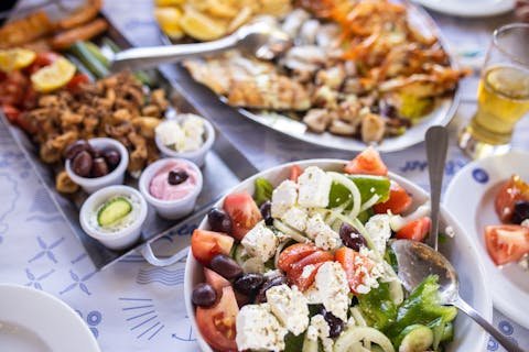 Kreikkalaista salaattia ja mereneläviä ruokapöydällä.