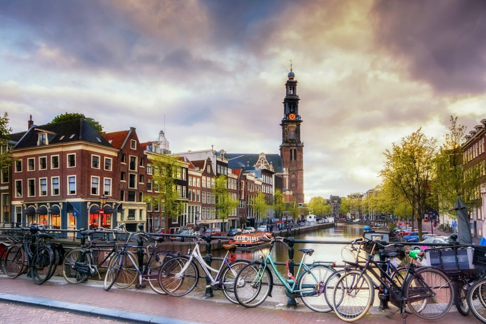 Näkymässä polkupyöriä Amsterdamin kanaalin edustalla.