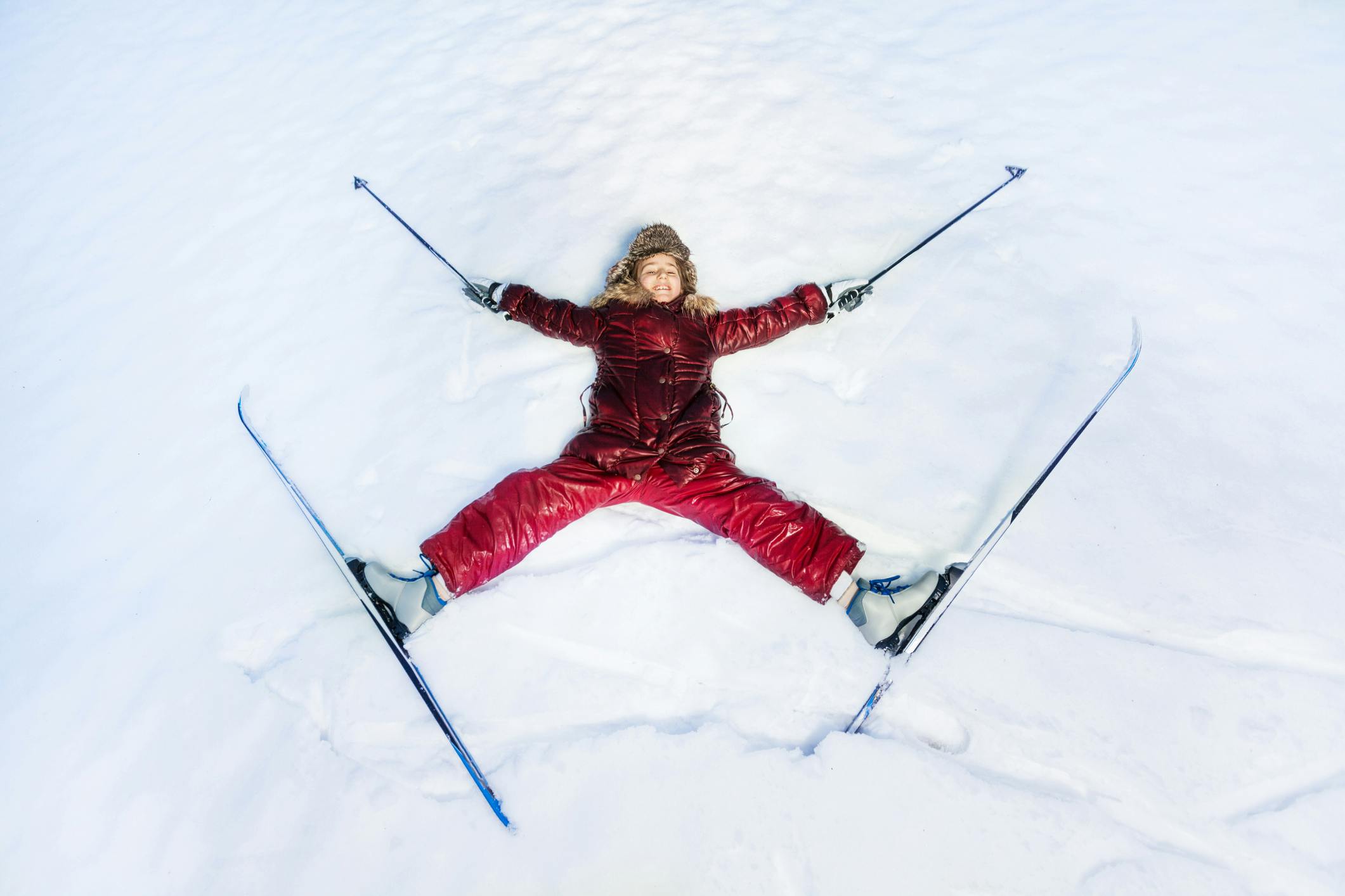 Onnellinen hiihtäjä makaa tähtenä lumessa.