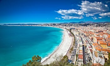 Ilmanäkymä Nizzan rantamaisemasta. Valkoinen pitkä hiekkaranta, turkoosi meri sekä kaupunkimaisemaa
