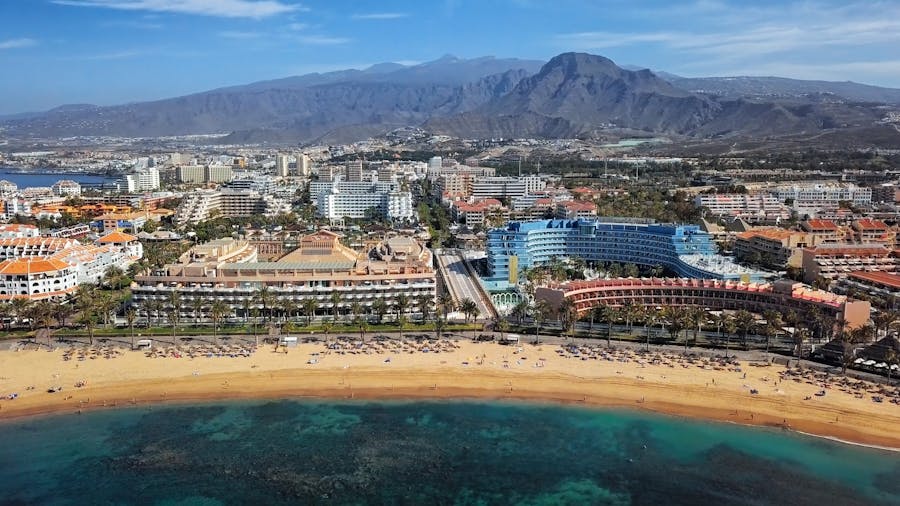 Ilmanäkymä jossa Playa de Los Cristianos rantamaisemaa. Taustalla myös kaupunkinäkymää ja vuoristoa
