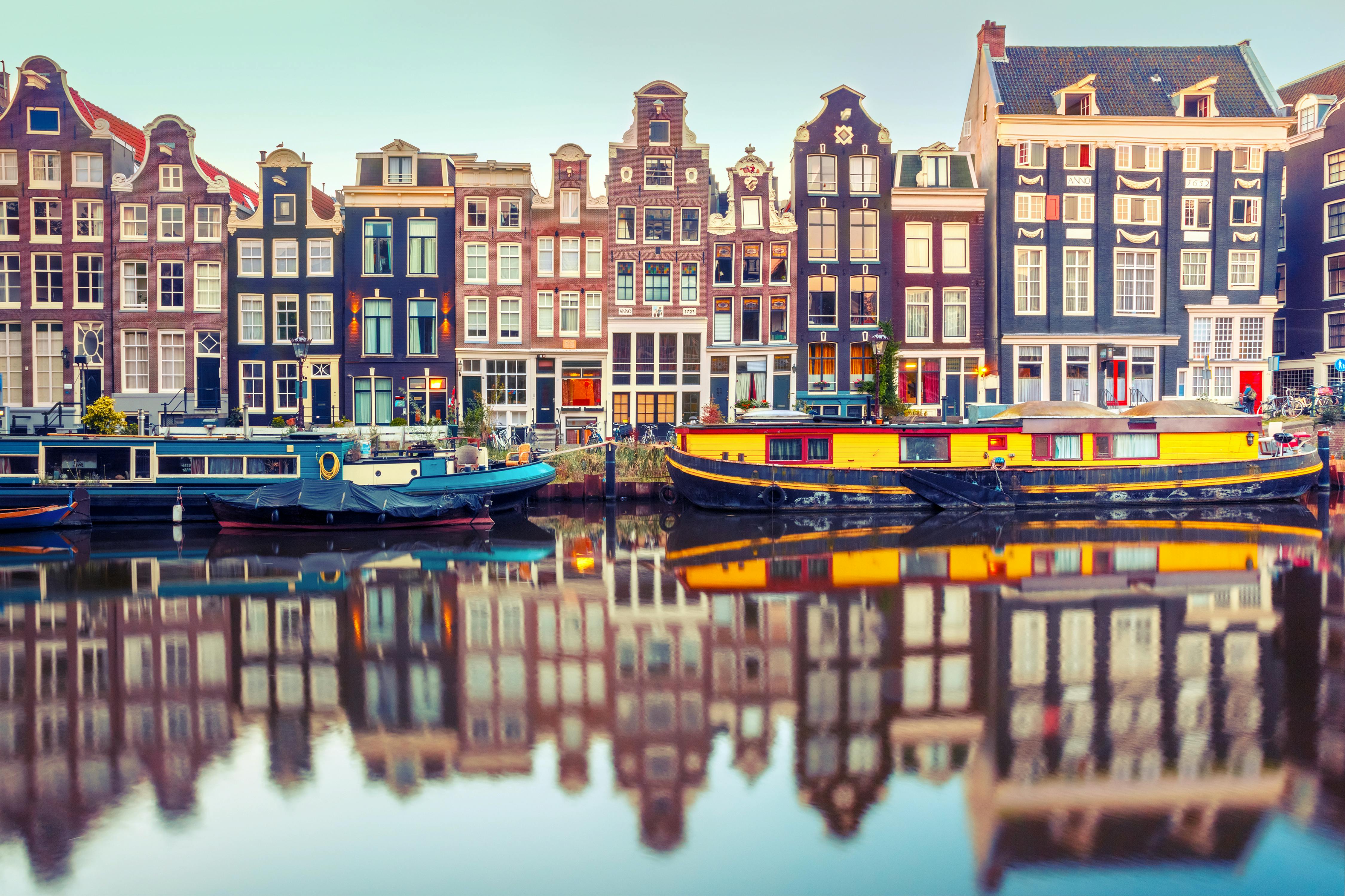 Näkymässä Amsterdamin värikkäitä taloja ja kanaali.
